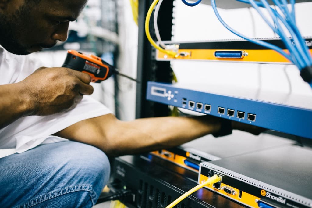 IT technician configuring server rack hardware and cabling